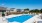 a swimming pool with a fence and houses in the background