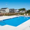 a swimming pool with a fence and houses in the background